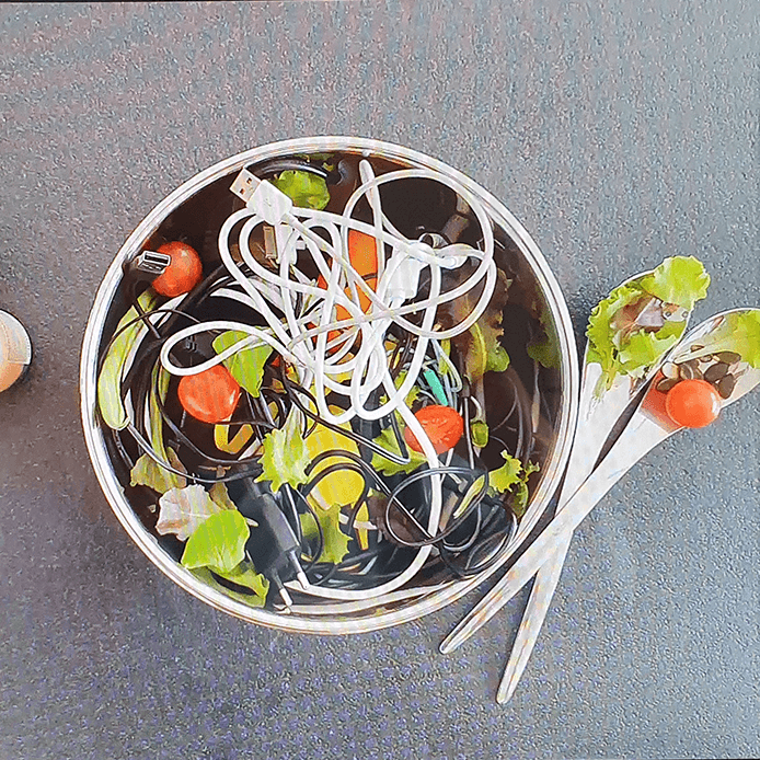 Topf mit echtem Salat und Kabelsalat, daneben zwei Löffel