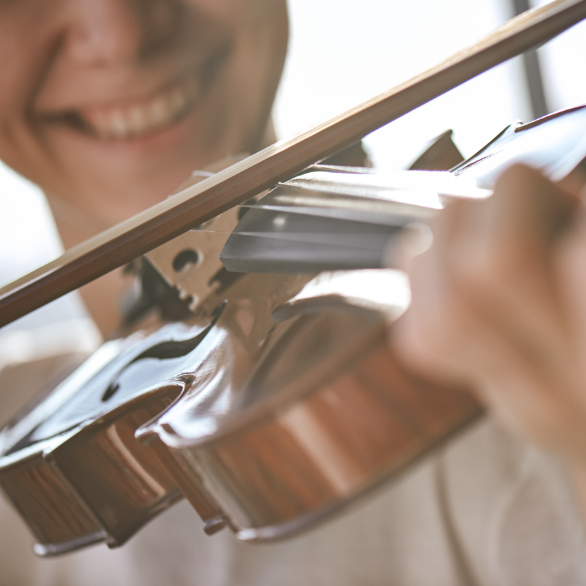 Nahaufnahme eines Jungen, der lächelnd Geige spielt