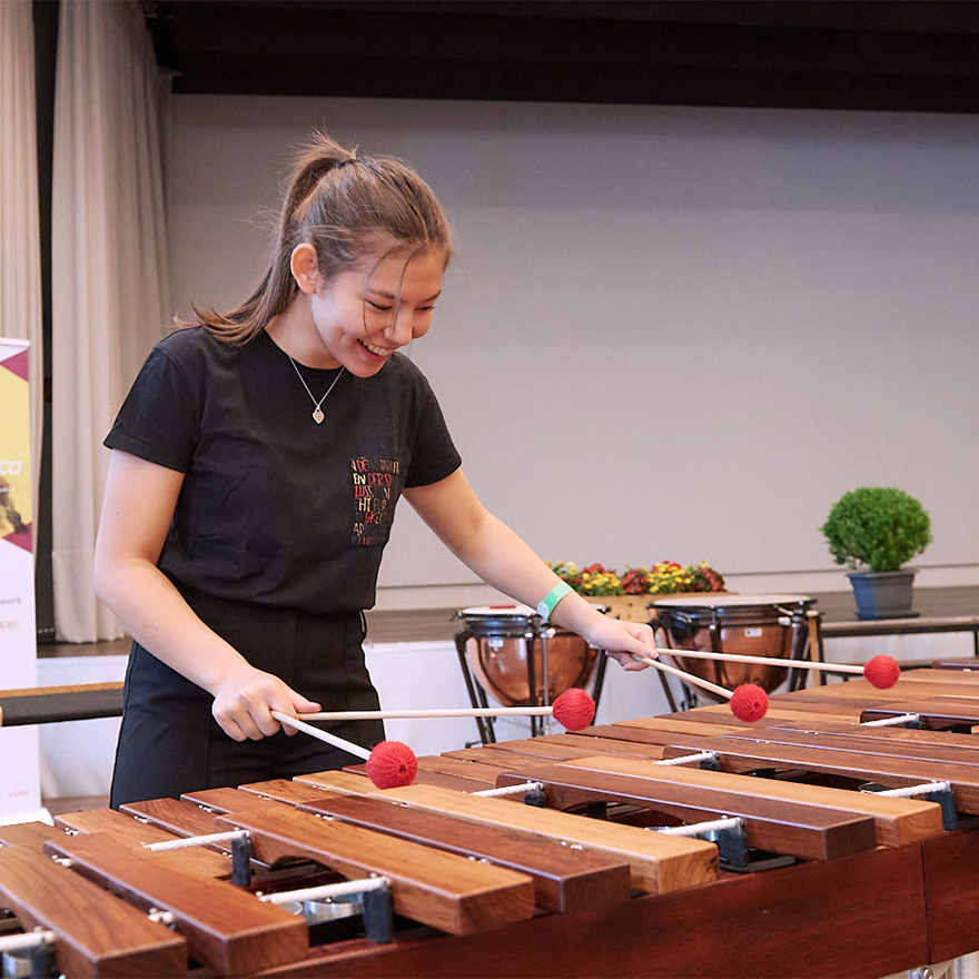 lächelndes Mädchen beim Marimba spielen